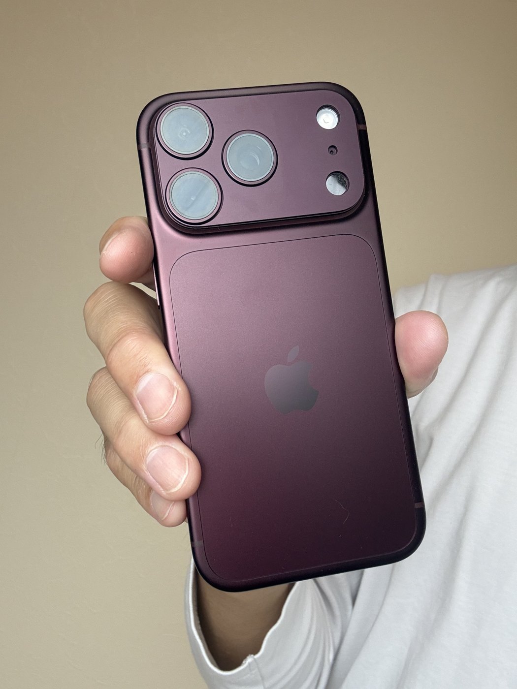 バーガンディのiPhone 18 Proを手に持った背面